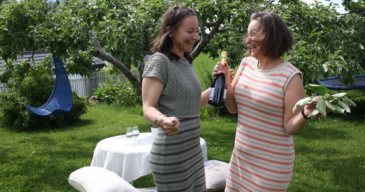 Sommerdag med oppdekning til hagefest, med to kjolebrukere som finner bobler til selskapet