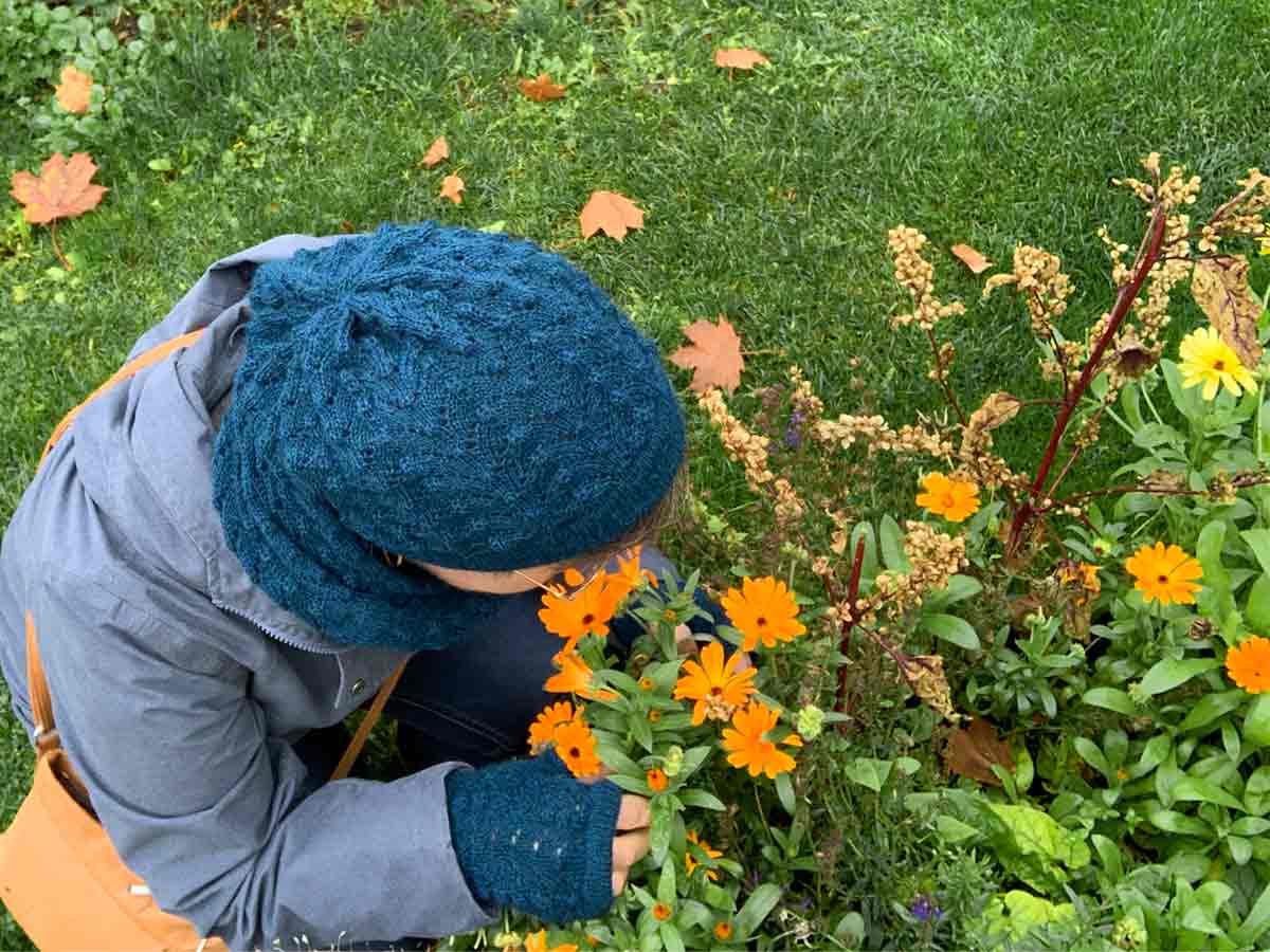 Modell lukter på ringblomster i høstkledd hage